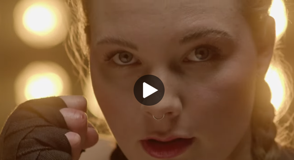 Vorschaubild zum Video 'Hungry for more'. Nahaufnahme einer Frau in Boxerpose.